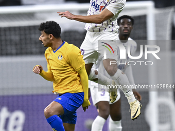 Ahmed Alganehi of Al Gharafa SC battles for the ball with Matias Palacios of Al Ain FC during the AFC Champions League elite west football m...