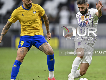 Jose Luis Mato of Al Gharafa SC battles for the ball with Yahia Nader of Al Ain FC during the AFC Champions League elite west football match...