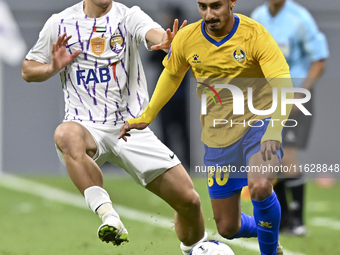 Ahmed Alganehi of Al Gharafa SC battles for the ball with Felipe Salomoni of Al Ain FC during the AFC Champions League elite west football m...