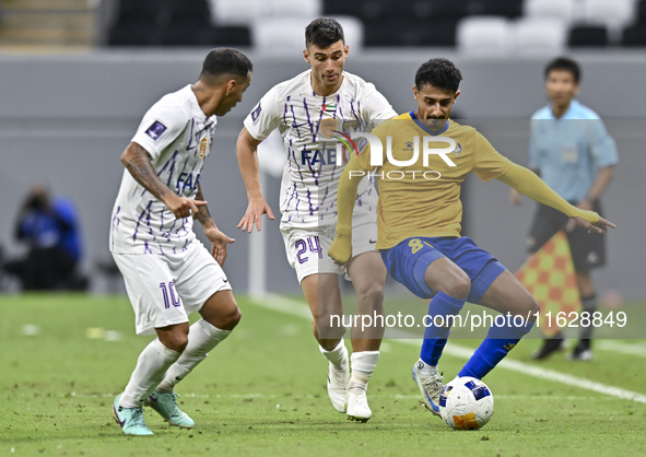 Ahmed Alganehi (R) of Al Gharafa SC battles for the ball with Felipe Salomoni (C) of Al Ain FC during the AFC Champions League elite west fo...