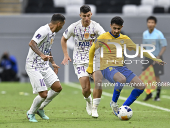 Ahmed Alganehi (R) of Al Gharafa SC battles for the ball with Felipe Salomoni (C) of Al Ain FC during the AFC Champions League elite west fo...