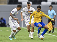 Ahmed Alganehi (R) of Al Gharafa SC battles for the ball with Felipe Salomoni (C) of Al Ain FC during the AFC Champions League elite west fo...