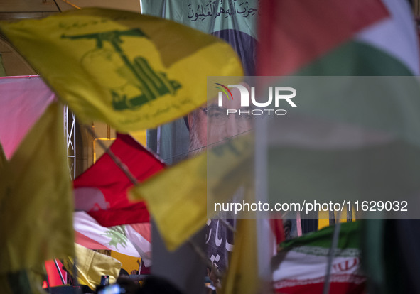 Iranians wave a flag of Lebanon's Hezbollah and a Palestinian flag in front of a portrait of Lebanon's Hezbollah Secretary General, Hassan N...