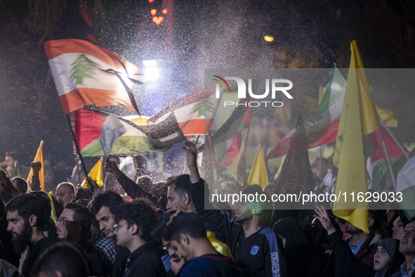 Iranians wave Lebanese flags and the Iranian flag while celebrating Iran's missile attack against Israel in Tehran, Iran, on October 1, 2024...