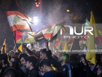 Iranians wave Lebanese flags and the Iranian flag while celebrating Iran's missile attack against Israel in Tehran, Iran, on October 1, 2024...