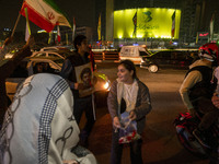 A young Iranian girl who does not wear a mandatory headscarf distributes sweets while celebrating Iran's missile attack against Israel in Te...