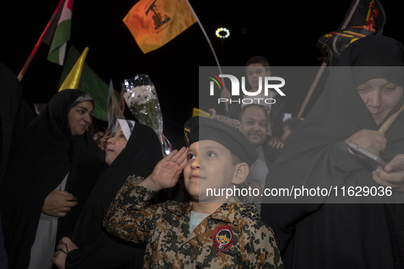 A young Iranian boy wearing an Islamic Revolutionary Guard Corps (IRGC) uniform salutes while attending Palestine Square to celebrate Iran's...