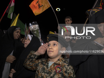 A young Iranian boy wearing an Islamic Revolutionary Guard Corps (IRGC) uniform salutes while attending Palestine Square to celebrate Iran's...