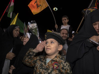 A young Iranian boy wearing an Islamic Revolutionary Guard Corps (IRGC) uniform salutes while attending Palestine Square to celebrate Iran's...