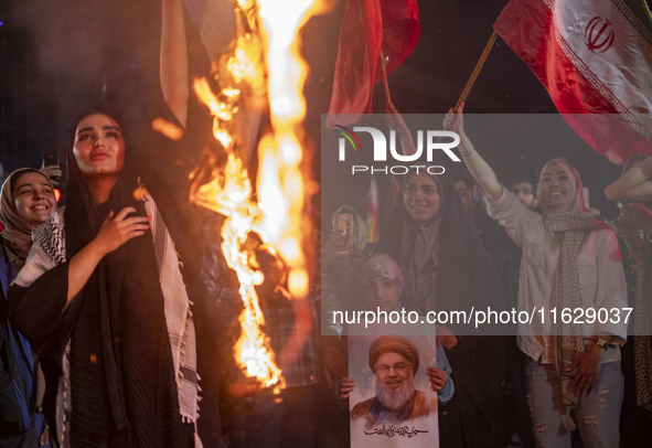 A young Iranian girl holds a portrait of Lebanon's Hezbollah Secretary General, Hassan Nasrallah, who was killed in an Israeli air strike in...