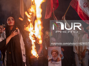 A young Iranian girl holds a portrait of Lebanon's Hezbollah Secretary General, Hassan Nasrallah, who was killed in an Israeli air strike in...