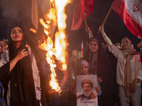 A young Iranian girl holds a portrait of Lebanon's Hezbollah Secretary General, Hassan Nasrallah, who was killed in an Israeli air strike in...