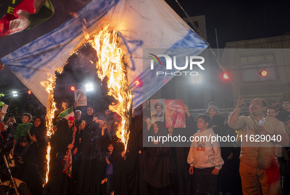 Iranian protesters burn an Israeli flag during a celebration for Iran's missile attack against Israel, in Tehran, Iran, on October 1, 2024....