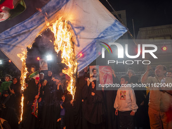 Iranian protesters burn an Israeli flag during a celebration for Iran's missile attack against Israel, in Tehran, Iran, on October 1, 2024....