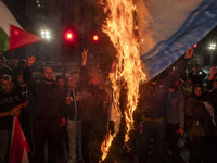 Iranian protesters shout anti-Israeli slogans while burning an Israeli flag in a celebration for Iran's missile attack against Israel, in Te...