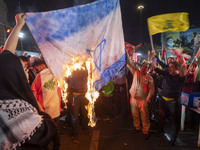 Iranian protesters shout anti-Israeli slogans while burning an Israeli flag in a celebration for Iran's missile attack against Israel, in Te...