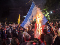 Iranian protesters shout anti-Israeli slogans while burning an Israeli flag in a celebration for Iran's missile attack against Israel, in Te...