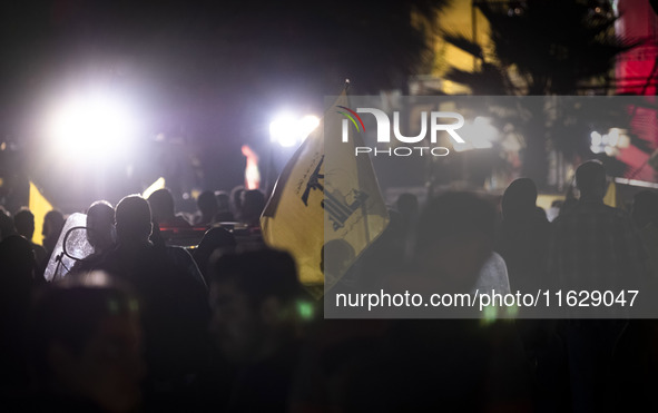 An Iranian man (not pictured) waves a flag of Lebanon's Hezbollah while celebrating Iran's missile attack against Israel in Tehran, Iran, on...