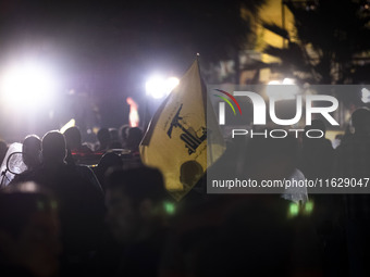 An Iranian man (not pictured) waves a flag of Lebanon's Hezbollah while celebrating Iran's missile attack against Israel in Tehran, Iran, on...