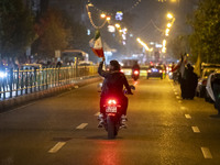 A motorcyclist carries an Iranian flag while celebrating Iran's missile attack against Israel in Tehran, Iran, on October 1, 2024. Iran laun...