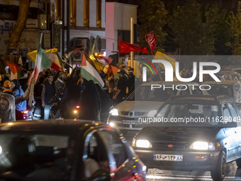 Iranians wave Lebanon's Hezbollah flags and a Palestinian flag while celebrating Iran's missile attack against Israel in Tehran, Iran, on Oc...