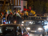 Iranians wave Lebanon's Hezbollah flags and a Palestinian flag while celebrating Iran's missile attack against Israel in Tehran, Iran, on Oc...