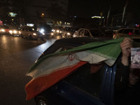 An Iranian man waves an Iranian flag while celebrating Iran's missile attack against Israel in Tehran, Iran, on October 1, 2024. Iran launch...