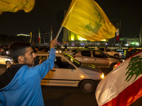 Iranian men wave a Hezbollah flag and a Palestinian flag while celebrating Iran's missile attack against Israel in Tehran, Iran, on October...