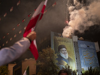 A man waves an Iranian flag next to a giant portrait of Lebanon's Hezbollah Secretary General, Hassan Nasrallah, who was killed in an Israel...