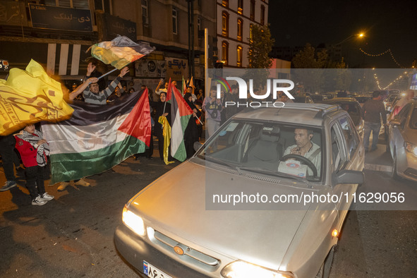 Iranians wave Palestinian flags while celebrating Iran's missile attack against Israel in Tehran, Iran, on October 1, 2024. Iran launches hu...