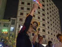 An Iranian man holds a portrait of Lebanon's Hezbollah Secretary General, Hassan Nasrallah, who was killed in an Israeli air strike in the s...