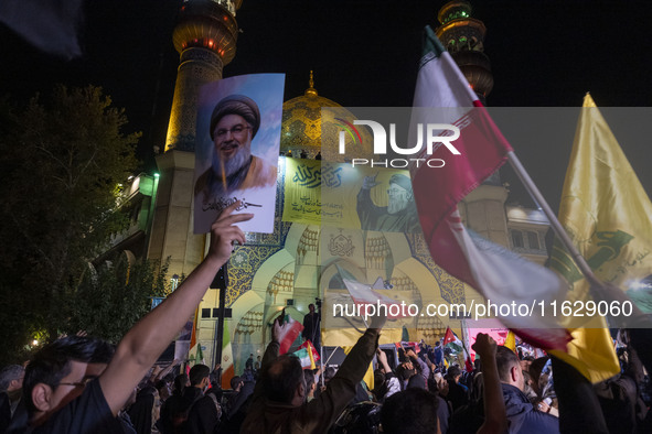 An Iranian man holds a portrait of Lebanon's Hezbollah Secretary General, Hassan Nasrallah, who was killed in an Israeli air strike in the s...