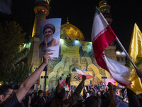 An Iranian man holds a portrait of Lebanon's Hezbollah Secretary General, Hassan Nasrallah, who was killed in an Israeli air strike in the s...