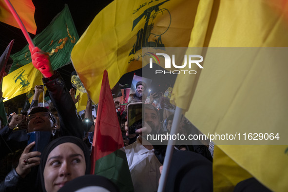 A man (not pictured) holds up a portrait of Lebanon's Hezbollah Secretary General, Hassan Nasrallah, who is killed in an Israeli air strike...