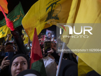 A man (not pictured) holds up a portrait of Lebanon's Hezbollah Secretary General, Hassan Nasrallah, who is killed in an Israeli air strike...