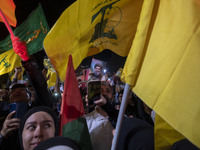 A man (not pictured) holds up a portrait of Lebanon's Hezbollah Secretary General, Hassan Nasrallah, who is killed in an Israeli air strike...