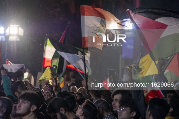 Iranians wave Lebanese and Palestinian flags while celebrating Iran's missile attack against Israel in Tehran, Iran, on October 1, 2024. Ira...