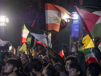 Iranians wave Lebanese and Palestinian flags while celebrating Iran's missile attack against Israel in Tehran, Iran, on October 1, 2024. Ira...