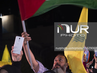 An Iranian man waves a Palestinian flag while celebrating Iran's missile attack against Israel in Tehran, Iran, on October 1, 2024. Iran lau...