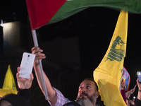 An Iranian man waves a Palestinian flag while celebrating Iran's missile attack against Israel in Tehran, Iran, on October 1, 2024. Iran lau...