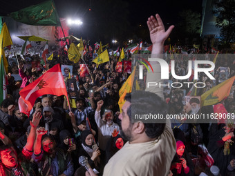 Iranians wave flags and shout anti-Israeli and anti-U.S. slogans while celebrating Iran's missile attack against Israel in Tehran, Iran, on...