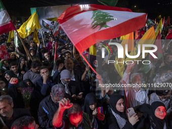 Iranians wave flags and shout anti-Israeli and anti-U.S. slogans while celebrating Iran's missile attack against Israel in Tehran, Iran, on...