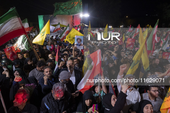 Iranians wave flags and shout anti-Israeli and anti-U.S. slogans while celebrating Iran's missile attack against Israel in Tehran, Iran, on...