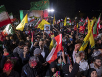 Iranians wave flags and shout anti-Israeli and anti-U.S. slogans while celebrating Iran's missile attack against Israel in Tehran, Iran, on...