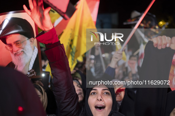 An Iranian woman shouts anti-Israeli slogans while standing next to a portrait of Iran's Supreme Leader, Ayatollah Ali Khamenei, as she take...