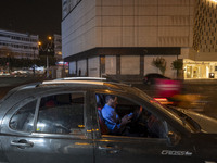 An Iranian man sits in his vehicle in downtown Tehran, Iran, on October 1, 2024, while checking the latest news about Iran's missile attack...