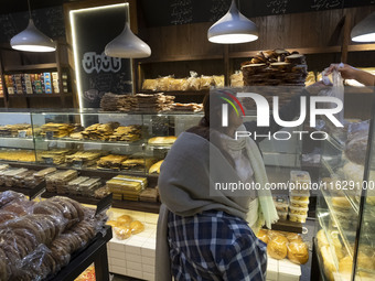 Two Iranian women shop for bread at a bakery in downtown Tehran, Iran, on October 1, 2024, after Iran's missile attack against Israel. Iran...