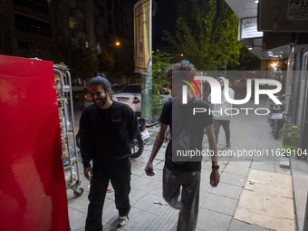 Iranian youths walk along a sidewalk in downtown Tehran, Iran, on October 1, 2024, after Iran's missile attack against Israel. Iran launches...