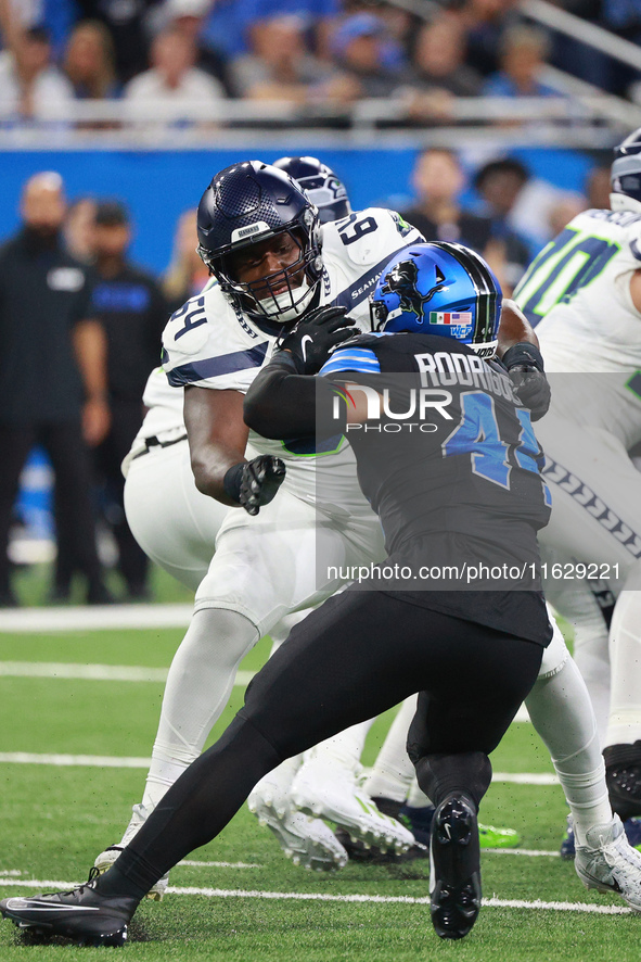 DETROIT,MICHIGAN-September 30: Seattle Seahawks guard Christian Haynes (64) defends against Detroit Lions linebacker Malcolm Rodriguez (44)...