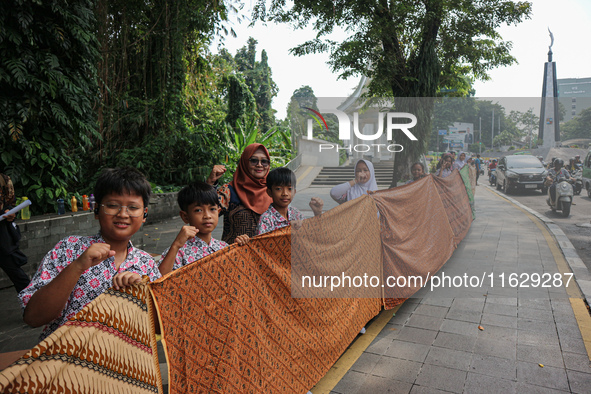 Several students and Bogor residents spread a 4-kilometer-long batik cloth along the pedestrian path, on October 2, 2024. UNESCO designated...